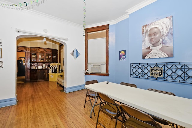 dining space with crown molding, cooling unit, and wood-type flooring