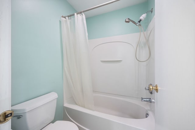 bathroom featuring shower / tub combo with curtain and toilet