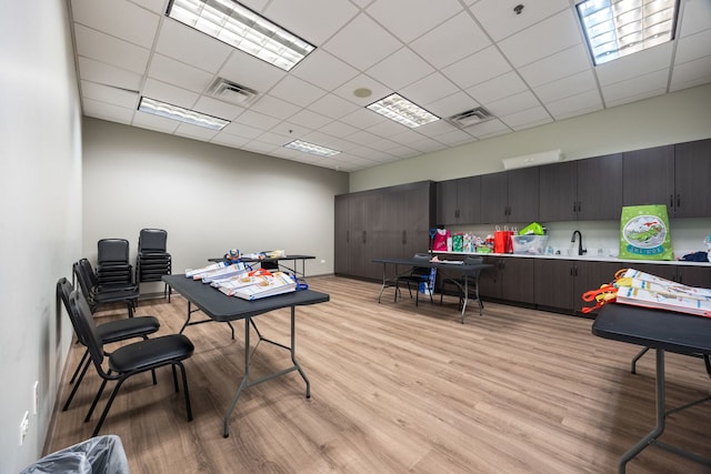 office area featuring a drop ceiling, sink, and light hardwood / wood-style flooring