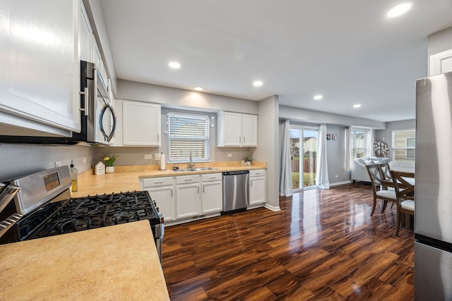 kitchen featuring white cabinetry, sink, appliances with stainless steel finishes, and dark wood-type flooring