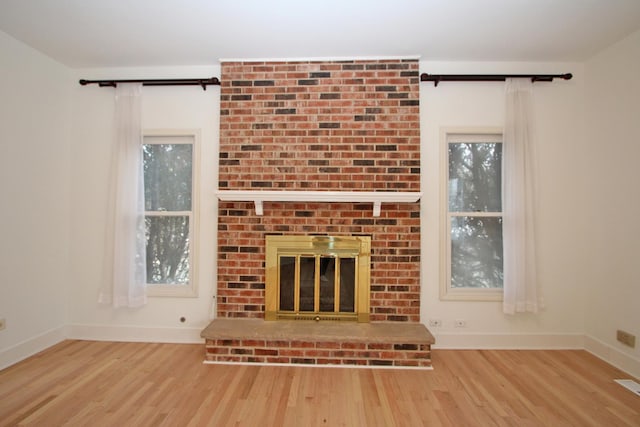 unfurnished living room with a fireplace and light hardwood / wood-style floors