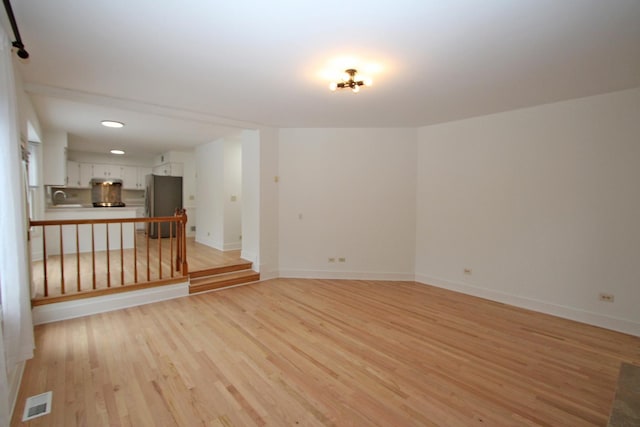 unfurnished room featuring light wood-type flooring and sink