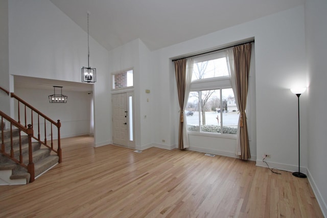 foyer entrance featuring light wood-type flooring and high vaulted ceiling