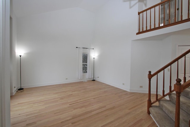 interior space with light wood-type flooring and high vaulted ceiling