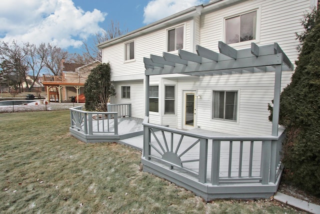 rear view of property with a pergola, a yard, and a deck