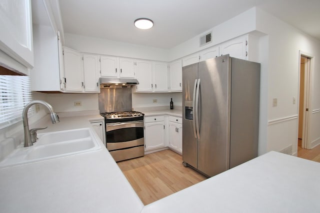 kitchen with white cabinetry, sink, light wood-type flooring, and appliances with stainless steel finishes