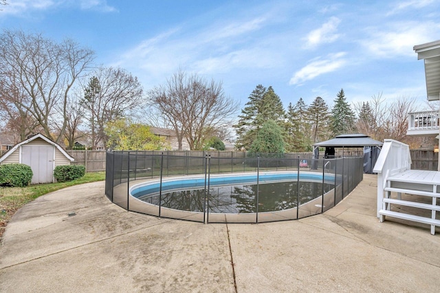 view of swimming pool with a gazebo, a shed, and a wooden deck