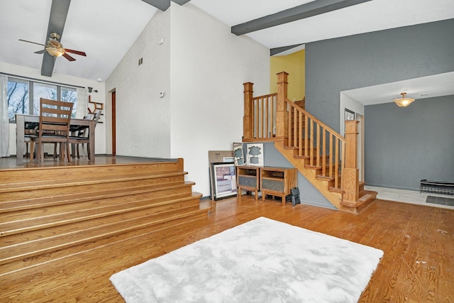 living room with wood-type flooring, lofted ceiling with beams, and ceiling fan