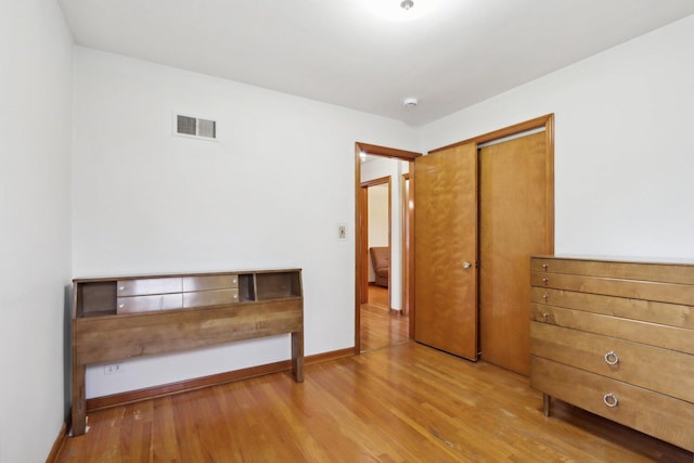 unfurnished bedroom featuring light wood-type flooring and a closet