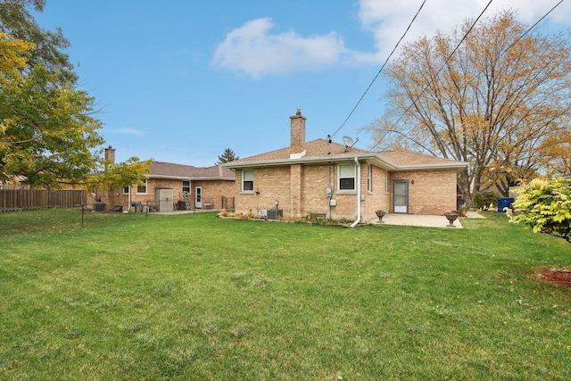 back of property with a lawn, a patio area, and central AC