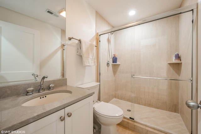 bathroom with an enclosed shower, vanity, and toilet