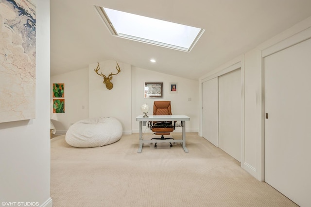 office with lofted ceiling with skylight and light carpet