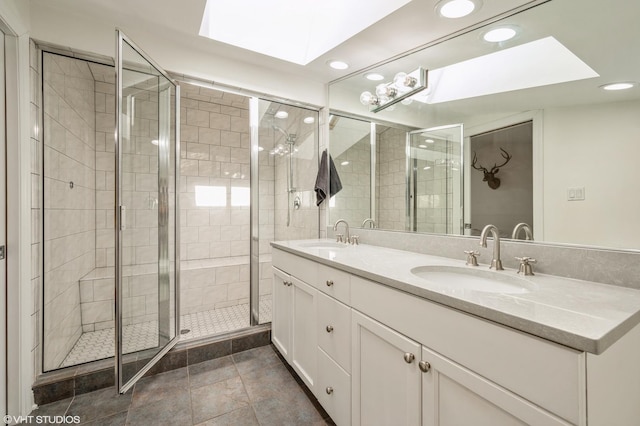 bathroom featuring a shower with door, a skylight, and vanity