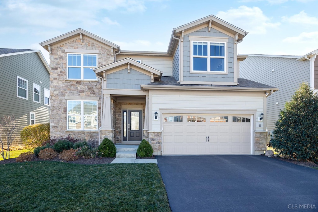 craftsman-style home with a front lawn and a garage