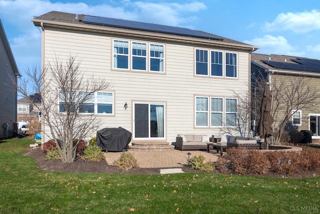 back of house featuring outdoor lounge area, solar panels, a patio, and a lawn