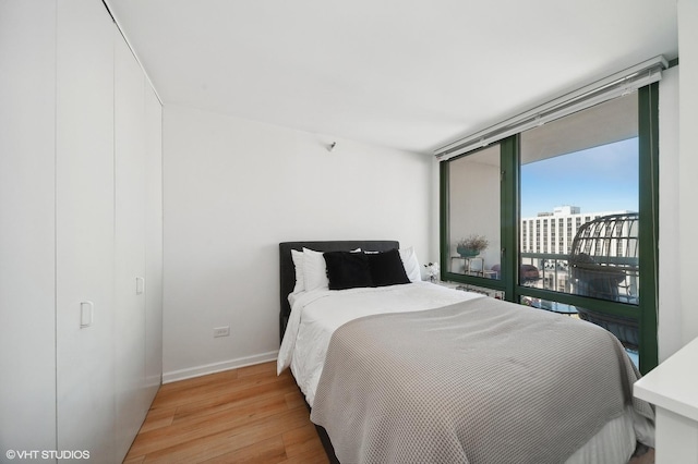 bedroom featuring access to exterior and light wood-type flooring