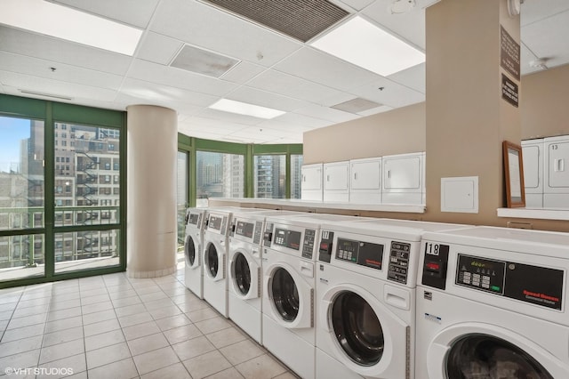 clothes washing area with separate washer and dryer and light tile patterned floors