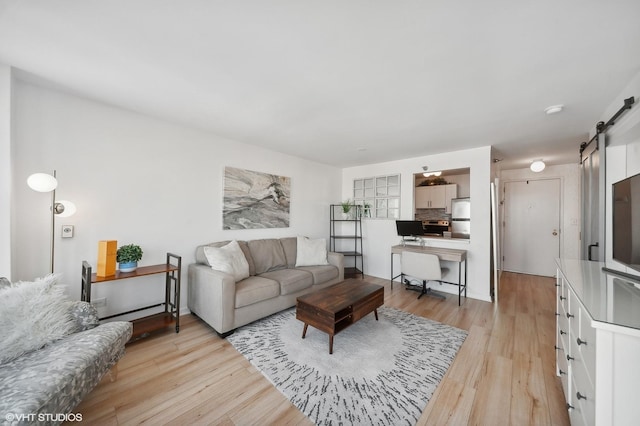 living room featuring a barn door and light hardwood / wood-style floors