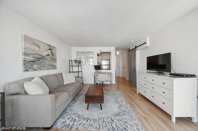 living room featuring light wood-type flooring and a barn door