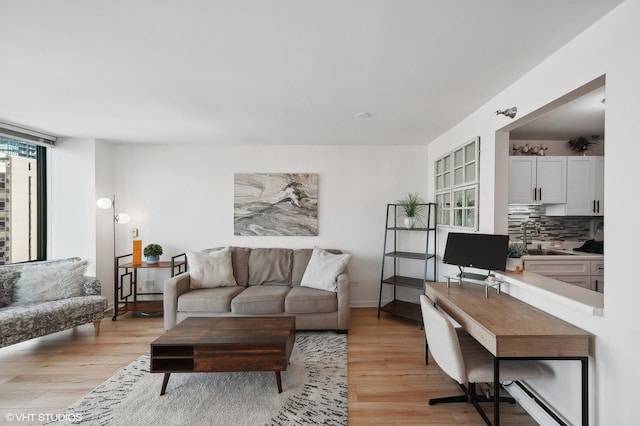 living room with sink and light hardwood / wood-style flooring