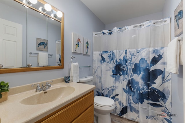 bathroom with walk in shower, vanity, and toilet