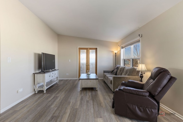 living room with hardwood / wood-style flooring, vaulted ceiling, and french doors