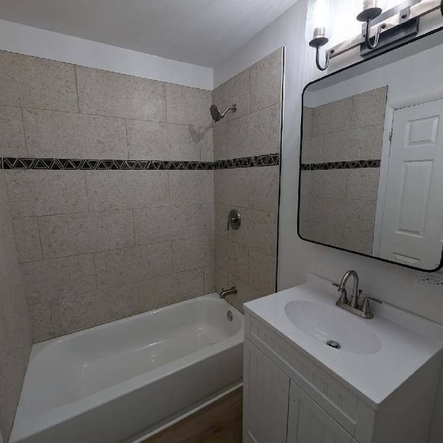 bathroom featuring vanity, wood-type flooring, and tiled shower / bath