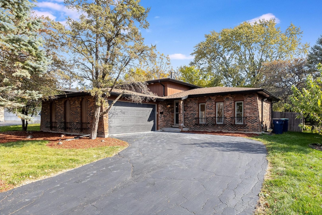 view of front of home with a garage and a front lawn