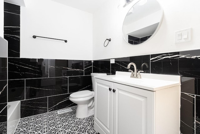 full bathroom with tile patterned flooring, vanity, toilet, and tile walls