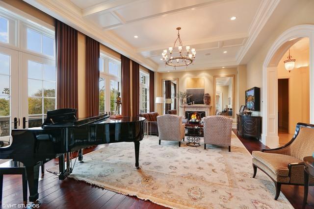 miscellaneous room featuring coffered ceiling, crown molding, hardwood / wood-style flooring, beam ceiling, and a chandelier