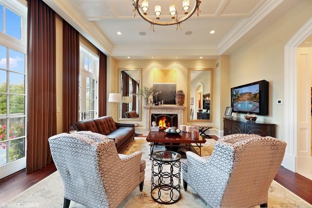 living room with beam ceiling, coffered ceiling, an inviting chandelier, hardwood / wood-style flooring, and ornamental molding