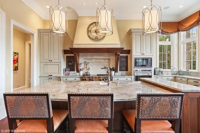 kitchen with built in microwave, pendant lighting, oven, and a spacious island