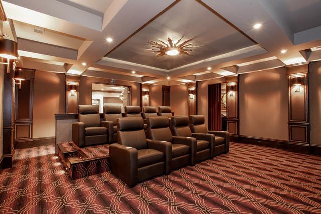 cinema room featuring dark colored carpet and a raised ceiling