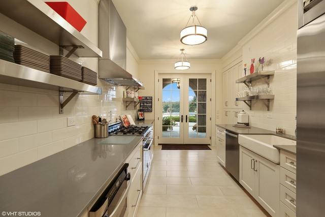 kitchen with white cabinetry, french doors, wall chimney exhaust hood, pendant lighting, and appliances with stainless steel finishes