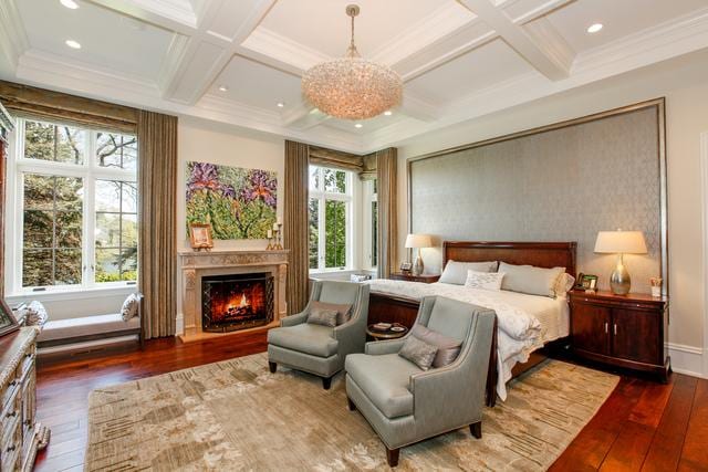 bedroom featuring hardwood / wood-style flooring, ornamental molding, beamed ceiling, and coffered ceiling