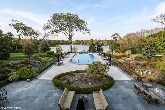 view of pool with a fire pit, a patio area, and a water view