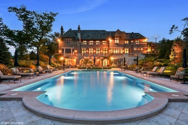 pool at dusk featuring a patio area