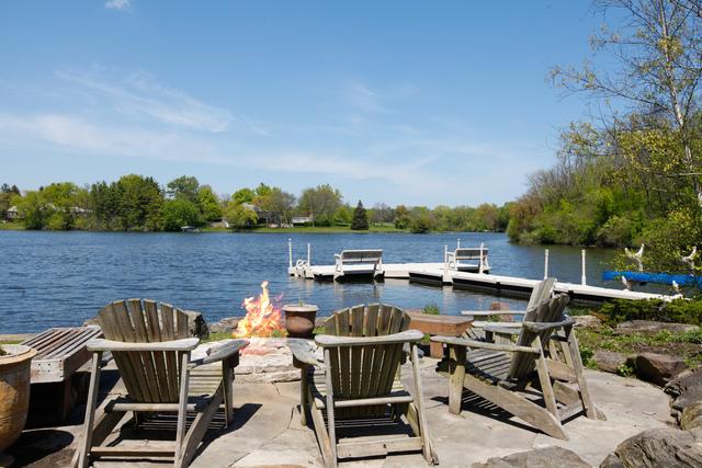 view of dock featuring a water view, an outdoor fire pit, and a patio