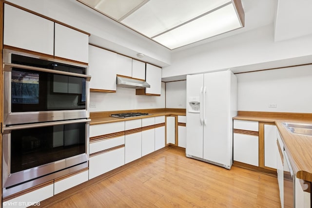 kitchen featuring stainless steel appliances, light wood-style flooring, white cabinets, and under cabinet range hood