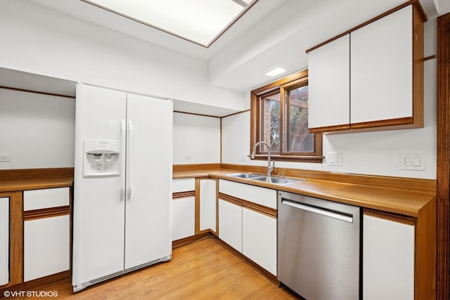 kitchen with light wood finished floors, dishwasher, white fridge with ice dispenser, white cabinetry, and a sink