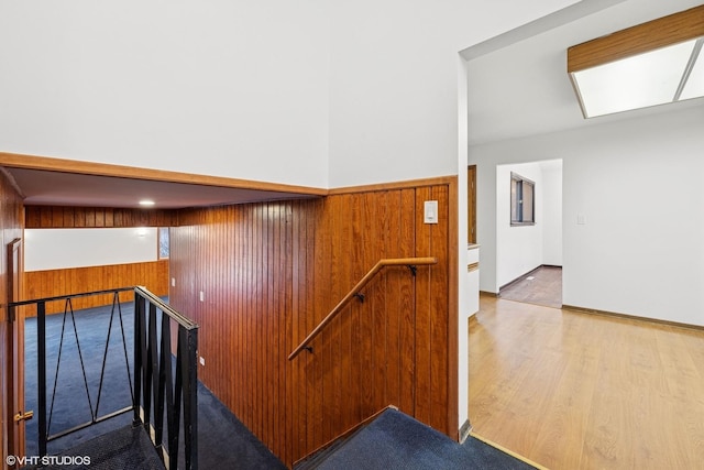 stairway featuring wood walls and wood finished floors