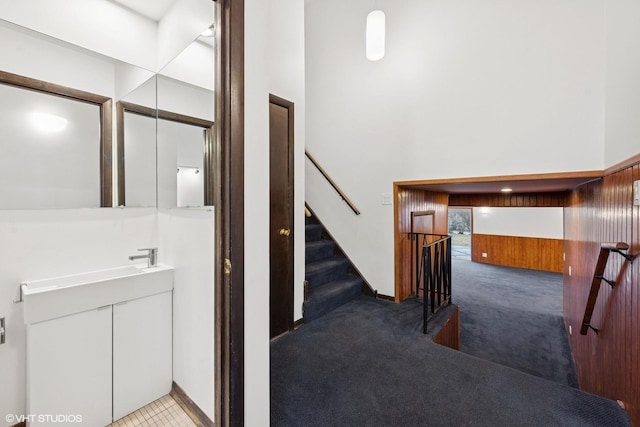 interior space featuring a towering ceiling, wooden walls, and vanity