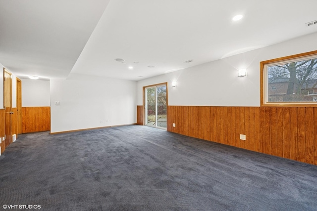 empty room featuring a wainscoted wall, carpet floors, wood walls, and recessed lighting