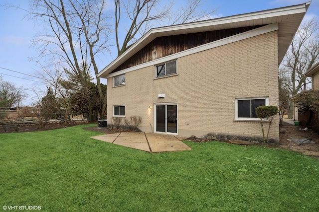 rear view of property with a patio area, brick siding, and a yard