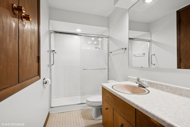 bathroom featuring a stall shower, vanity, toilet, and tile patterned floors