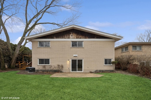 back of property featuring a patio, brick siding, and a lawn