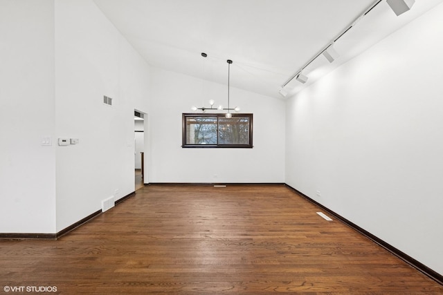 unfurnished dining area featuring a chandelier, visible vents, track lighting, and wood finished floors