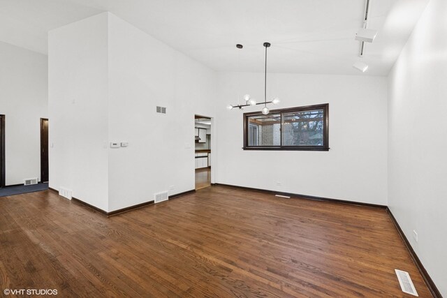 unfurnished dining area featuring track lighting, visible vents, and dark wood-type flooring