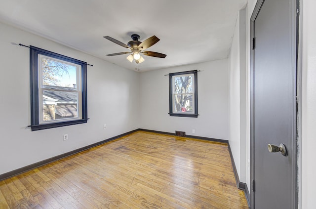 unfurnished room featuring plenty of natural light, light hardwood / wood-style floors, and ceiling fan