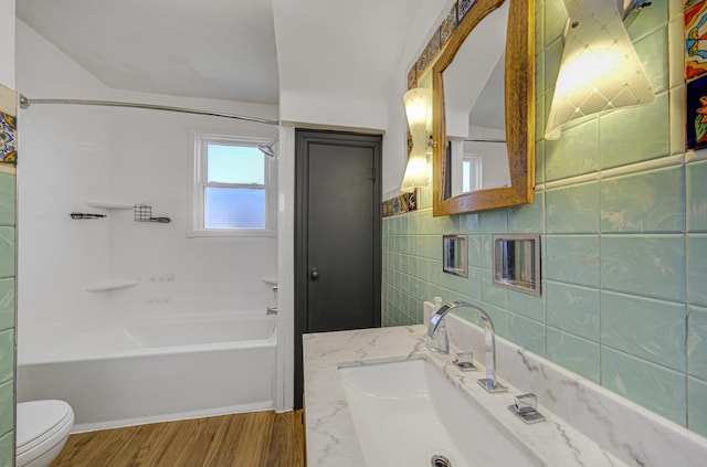 full bathroom with vanity, bathing tub / shower combination, wood-type flooring, tile walls, and toilet